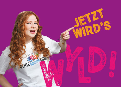 Die Postkarte zeigt ein Mädchen, das ein T-Shirt mit der Aufschrift "Werte machen Schule" trägt. Es deutet auf den Schriftzug: "Jetzt wird's WYLD".